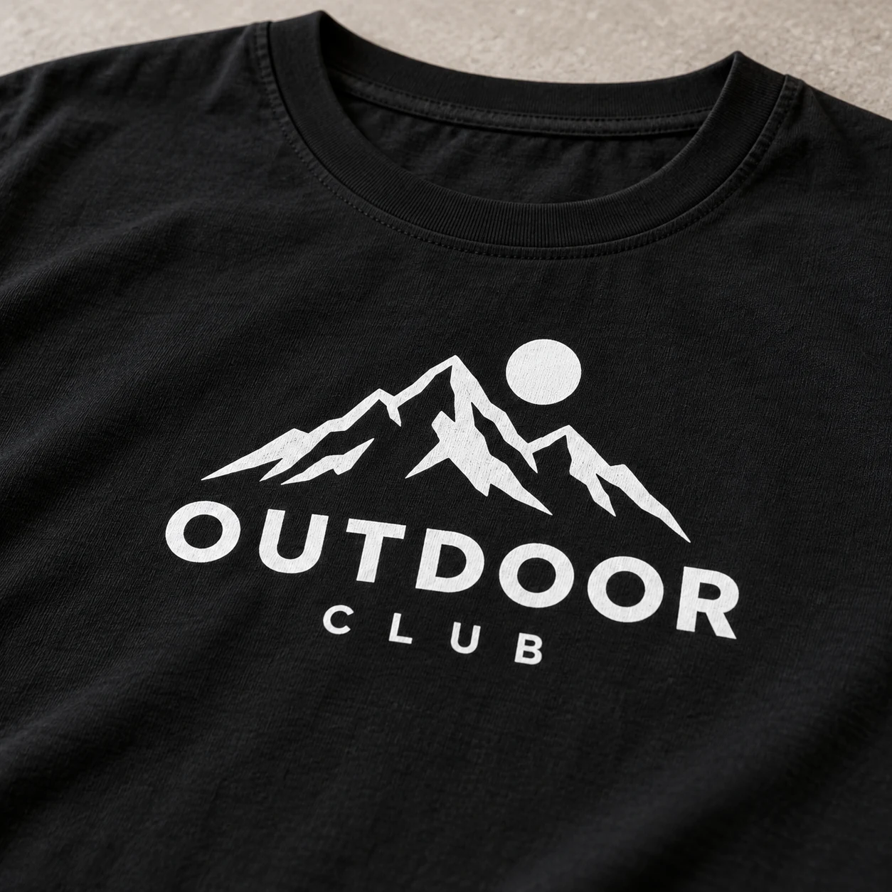 黒Tシャツに白い山のロゴとOUTDOOR CLUBの文字を印刷したイメージ