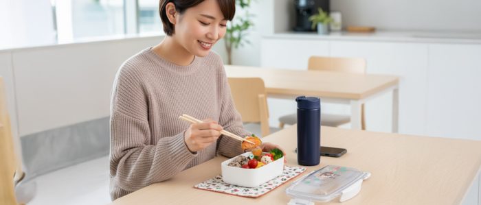 休憩室でお弁当を食べる女性
