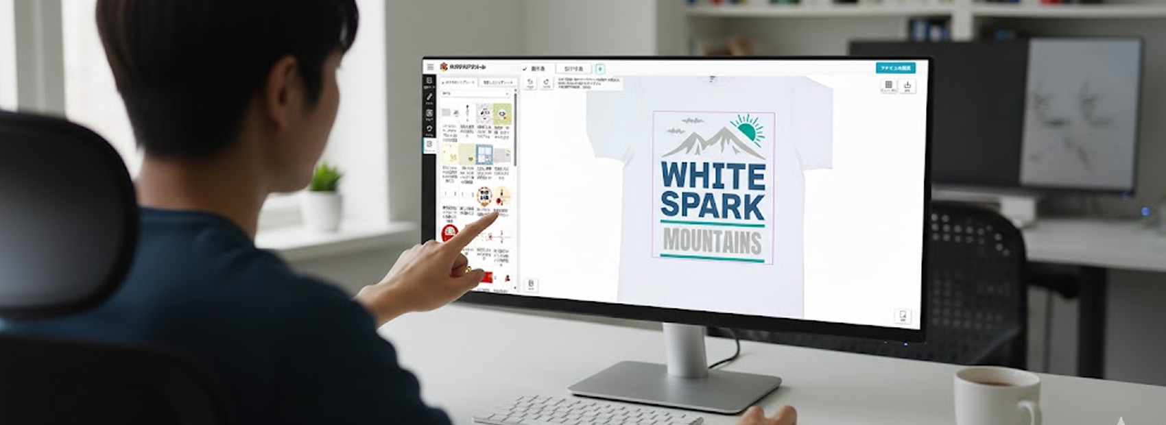 オリジナルプリント.jpのデザインツール画面が写ったPCモニターを操作する男性のイメージ。男性がマウスで画面上のテンプレートを指している。Tシャツのデザイン部分には「WHITE SPARK MOUNTAINS」の文字と山のイラストが表示されている。オフィスのような部屋で、手前にはキーボードとマグカップが置かれている。