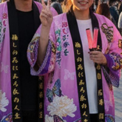 オリジナルデザインの法被を着て、ライブ会場の前で記念撮影をする仲間たち