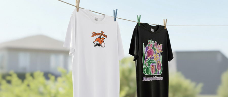 インクジェットプリント（DTG）で作られたTシャツ。グラデーションが綺麗なキャラクター柄と、色彩豊かな花柄のデザインが青空の下で干されている。